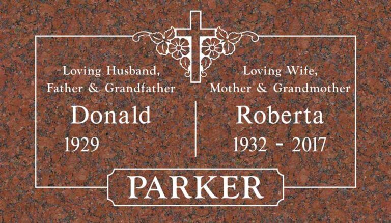 Granite companion grave marker with cross, flowers, and vine