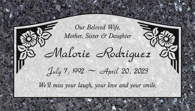 Granite headstone with arched top panel, flowers, and art deco column accents
