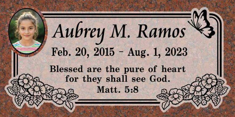 Granite headstone with butterfly, cascading flowers, and oval photo portrait