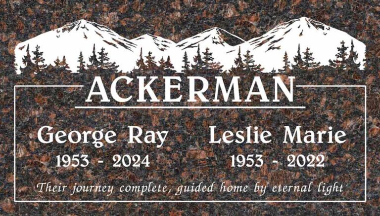Granite companion headstone with mountain range, sunrise, and pine trees