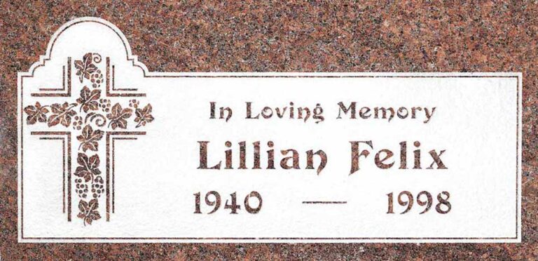 Granite headstone with cross, grapevine, and arched top panel