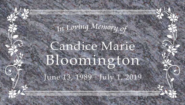 Granite headstone with floral vine clusters and scrollwork border