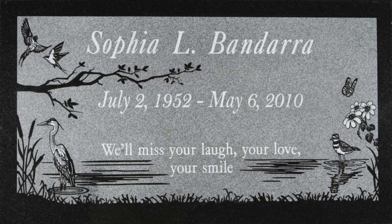 Granite headstone with heron, birds on branch, butterfly, and pond scene