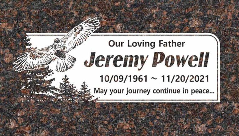 Granite memorial with soaring eagle over pine trees and frosted panel
