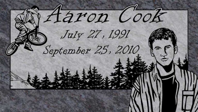 Granite memorial with portrait, BMX bike rider, and pine tree forest