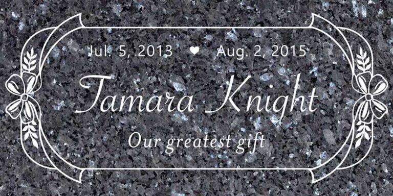 Granite memorial with ribbon bows, wheat sprigs, and scroll border