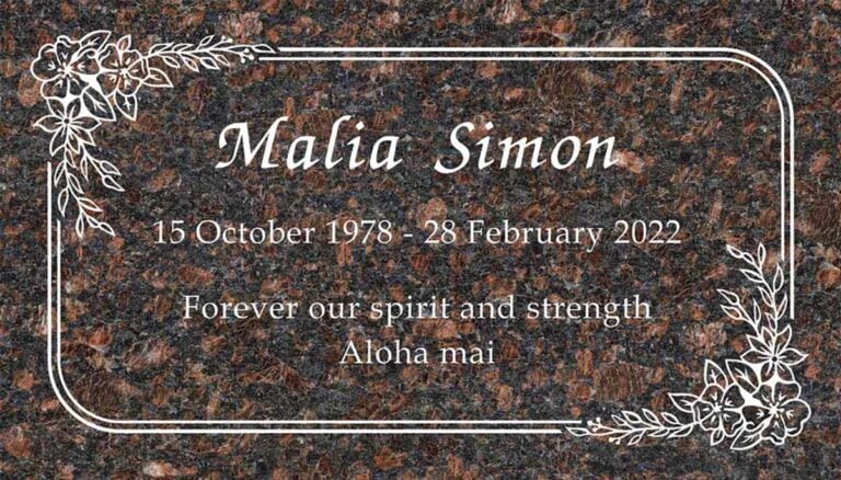 Granite memorial with tropical flower accents and rounded border