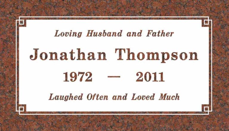 Granite memorial with white panel and decorative corner square accents