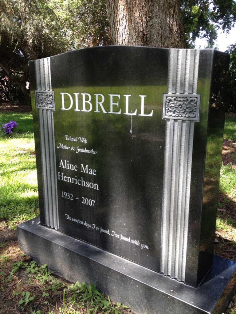 Granite monument with art deco column design and flower rosettes at Oak Park Cemetery in Claremont