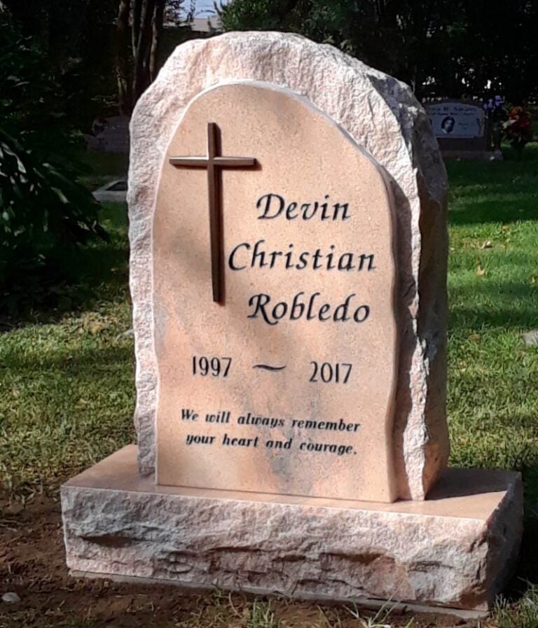 Granite monument with bronze cross and natural rock-pitched edges at Oak Park Cemetery in Claremont