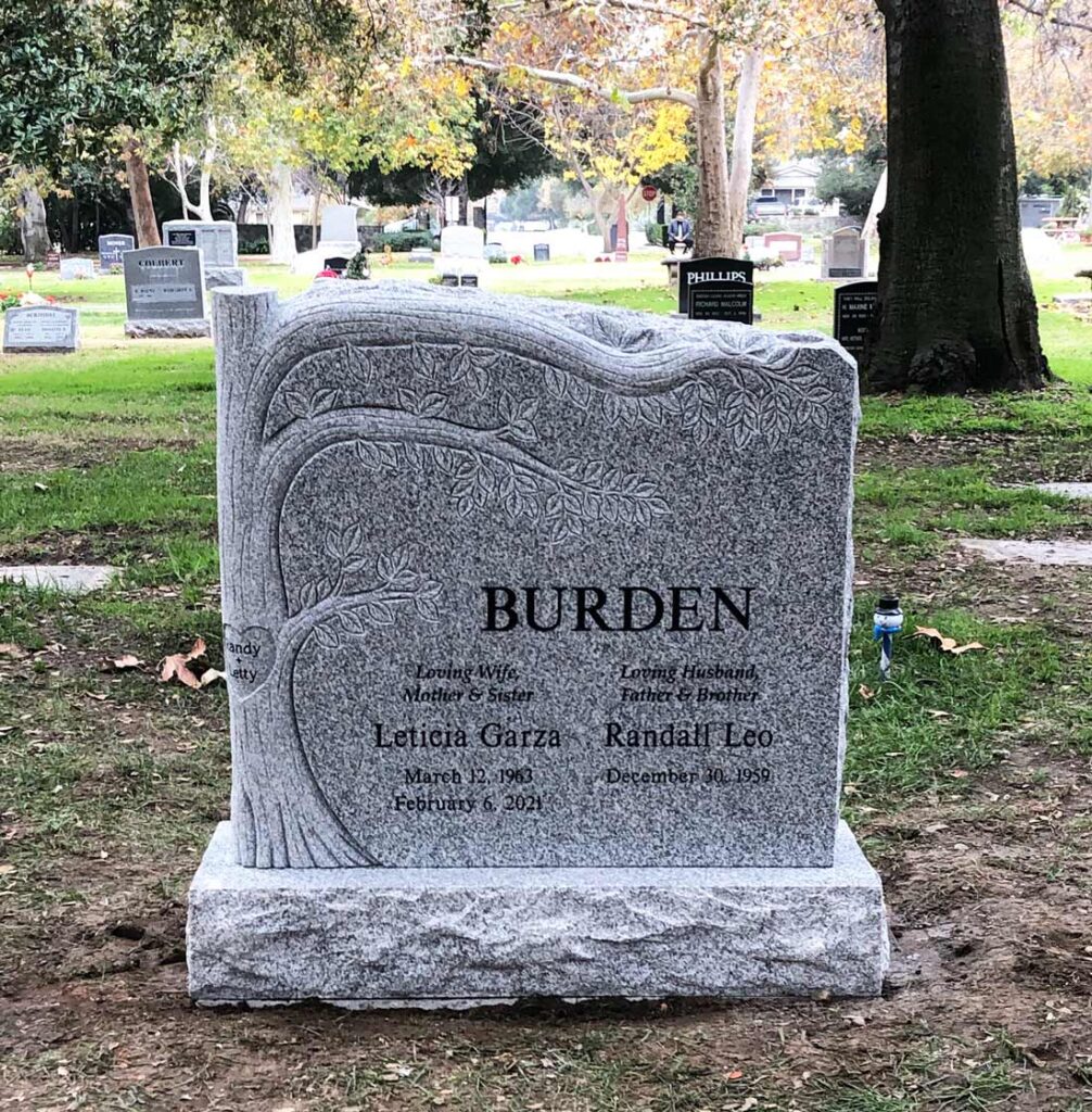 Granite slant memorial with carved tree design and natural rock edge at Oak Park Cemetery in Claremont