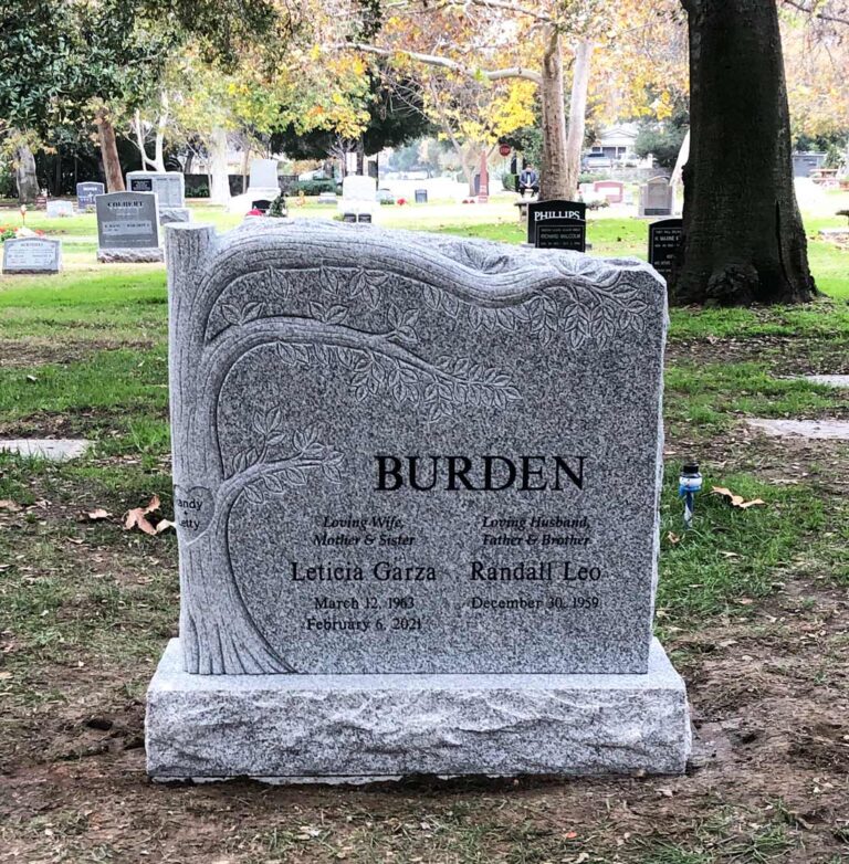 Granite slant memorial with carved tree design and natural rock edge at Oak Park Cemetery in Claremont