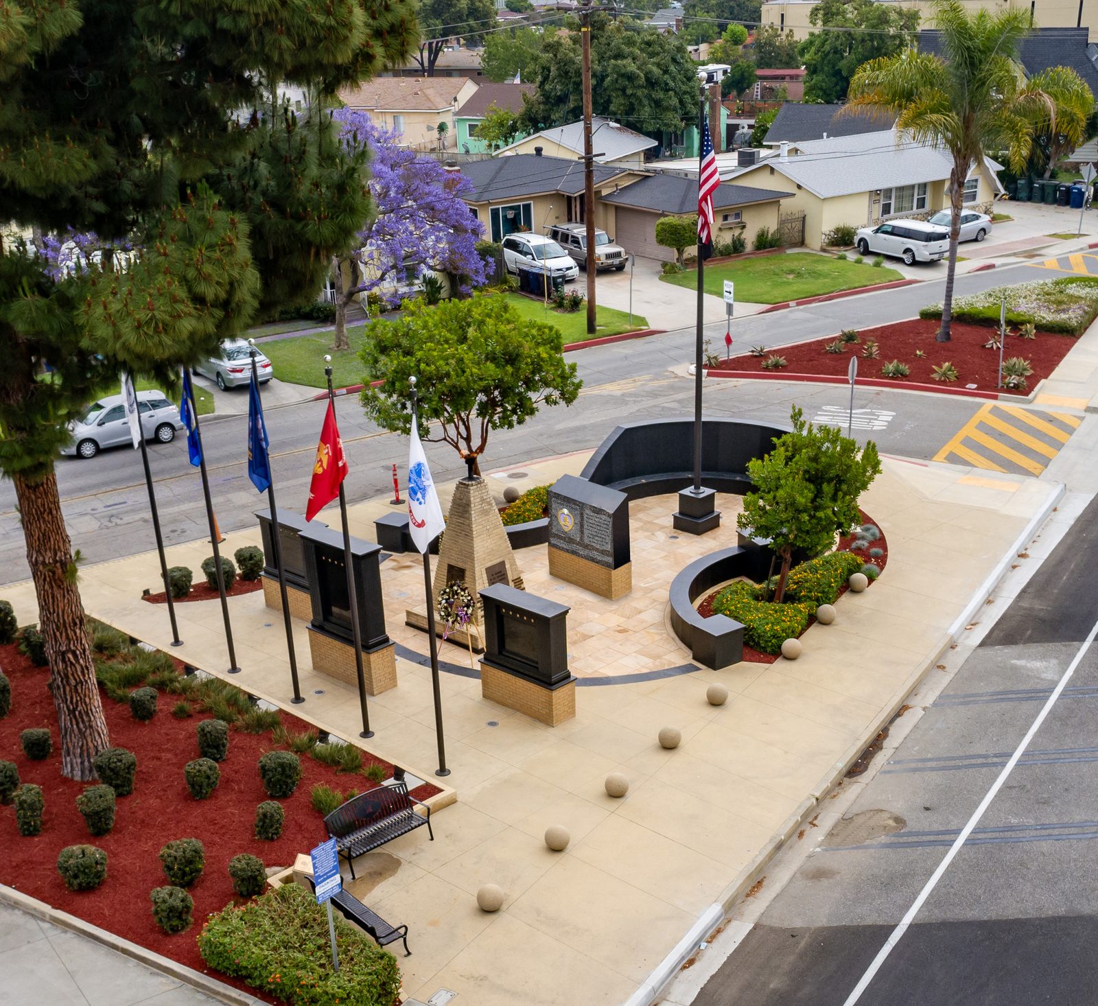 Aerial view of Veterans Memorial Plaza in Pico Rivera with the Purple Heart Monument, service flags, and curved granite wall