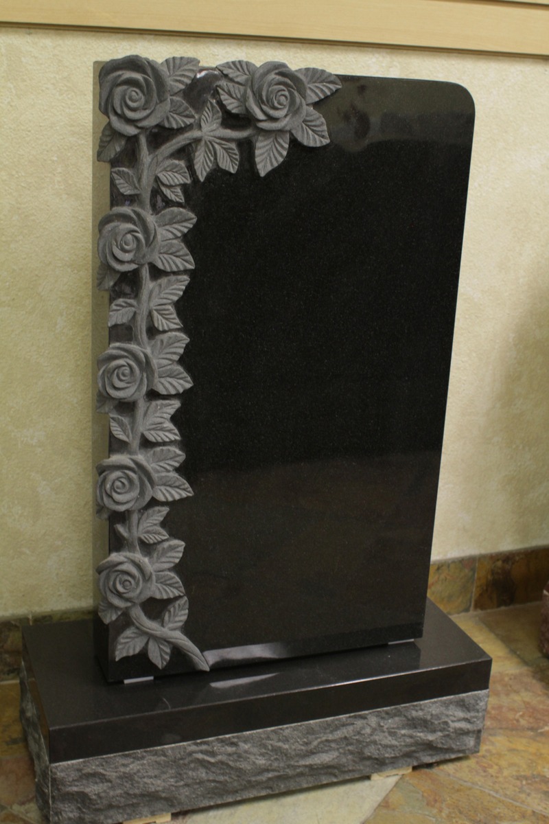 Black granite upright monument with carved rose vine