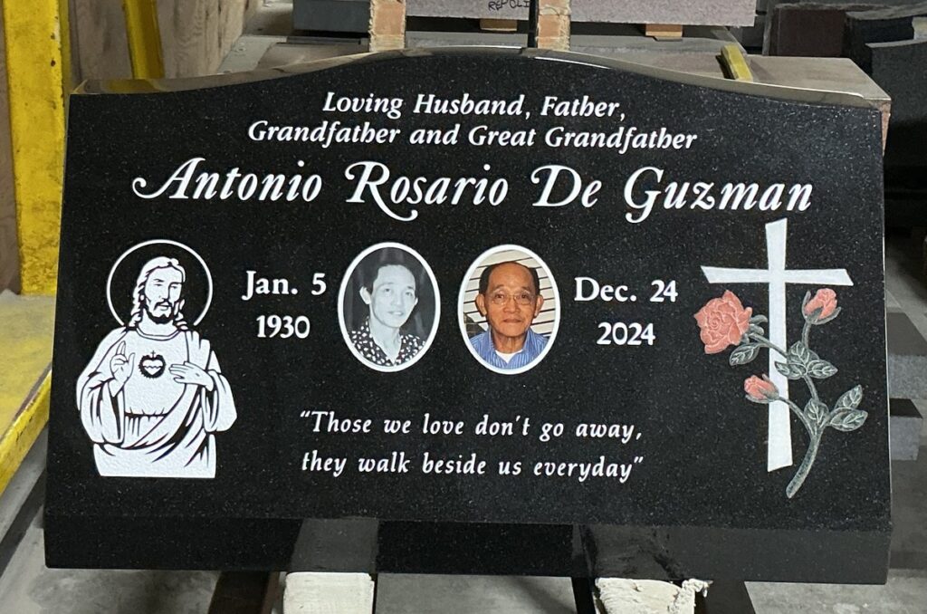Black granite slant memorial with sacred heart and cross, De Guzman family, Harbor Lawn-Mt. Olive Memorial Park