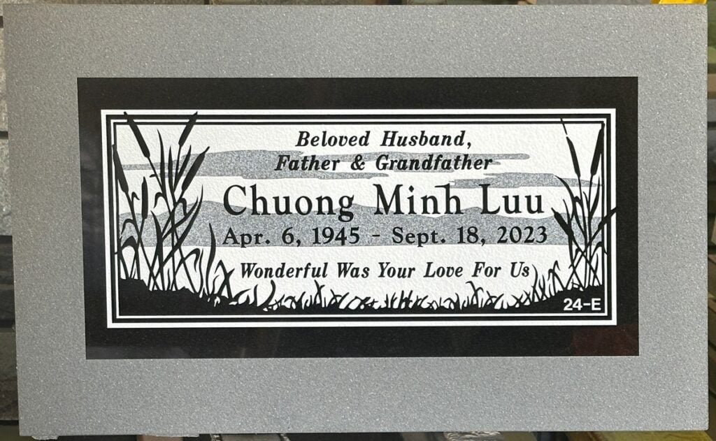 Black granite headstone with cattails and marsh, Luu family, Hillside Memorial Park